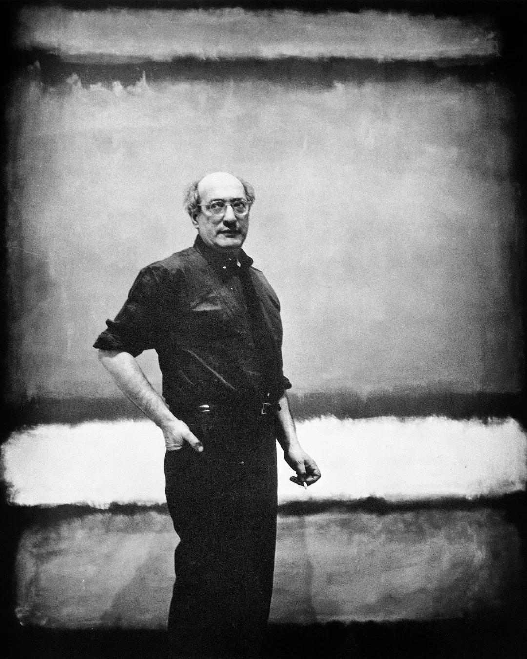 Mark Rothko, American abstract painter, pictured standing in front of one of his paintings