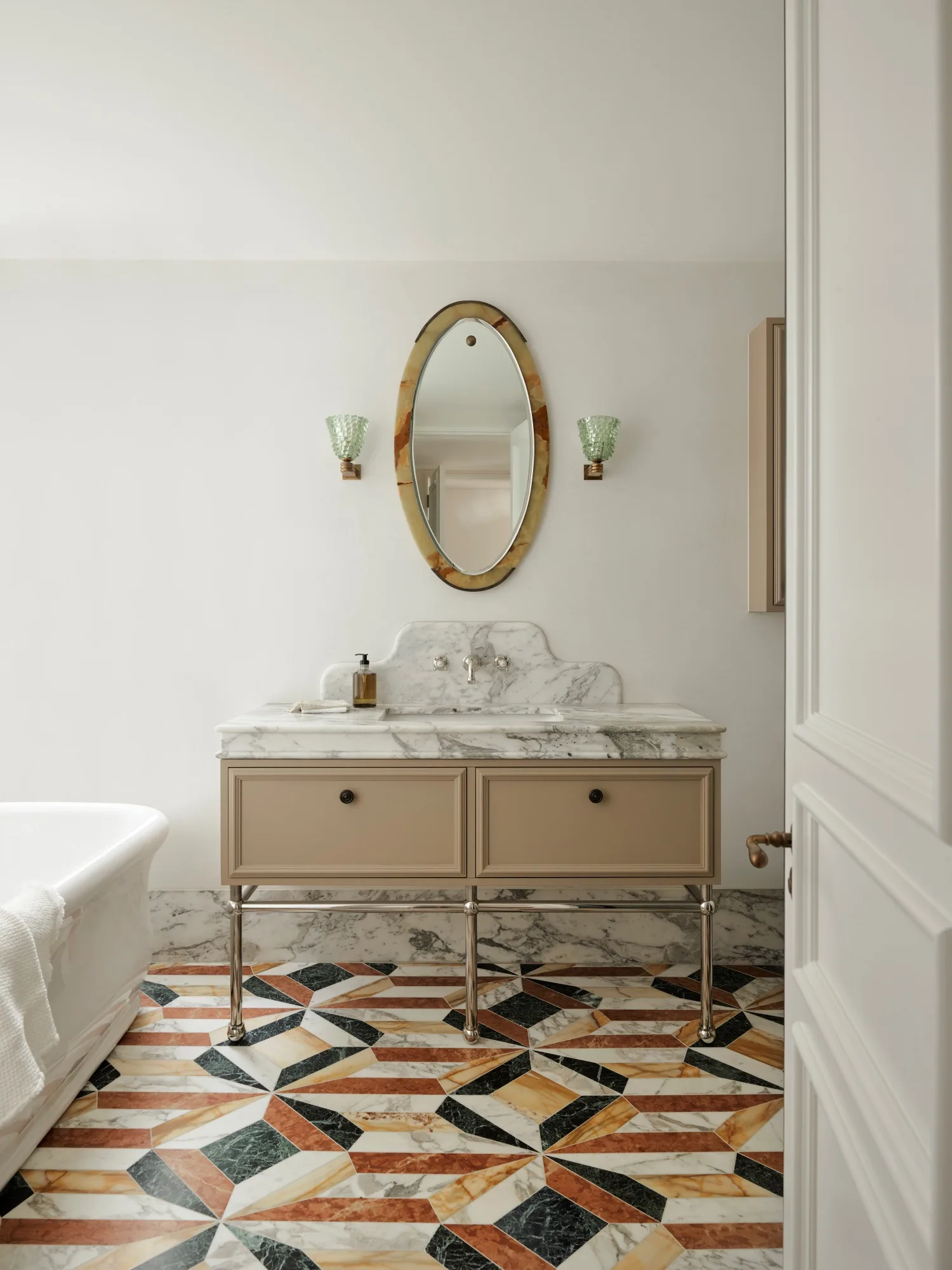 Elegant contemporary bathroom with marble floor, beige vanity, and oval mirror.