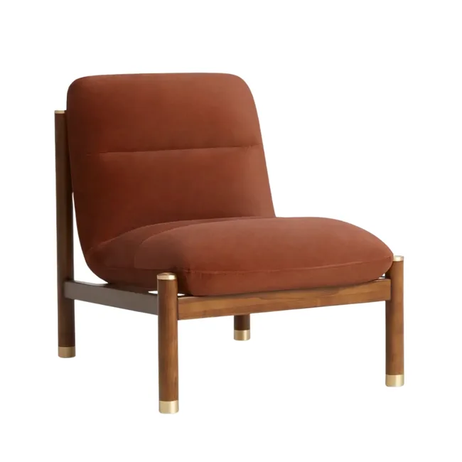 Armless brick red velvet armchair with minimal timber base