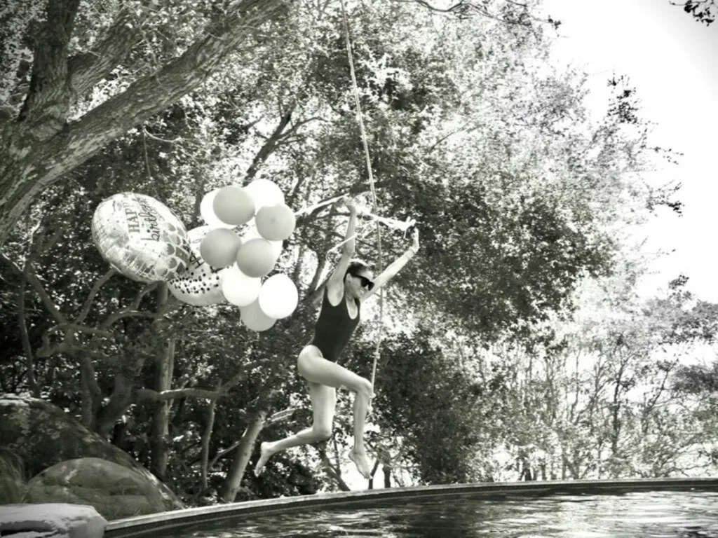 Meghan Markle jumps into a swimming pool holding birthday balloons during her 45th birthday celebrations.