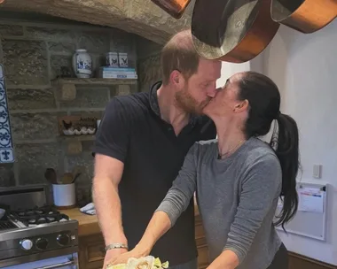 Meghan Markle and Prince Harry kiss beside a birthday cake in their rustic Montecito kitchen.