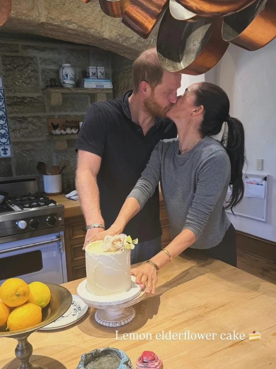 Meghan Markle and Prince Harry kiss beside a birthday cake in their rustic Montecito kitchen.