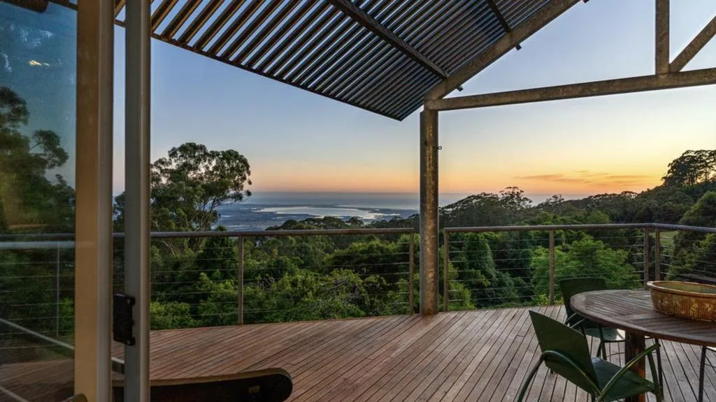 Sunset from the covered entertaining deck overlooking rainforest and the Pacific Ocean.