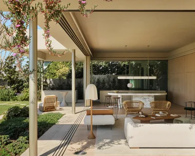 Open-plan living space. The large windows slide open to entirely open up the interior and exterior zones. Inside is an open-plan living and kitchen and on the facade of the building plants hang from the second storey down.