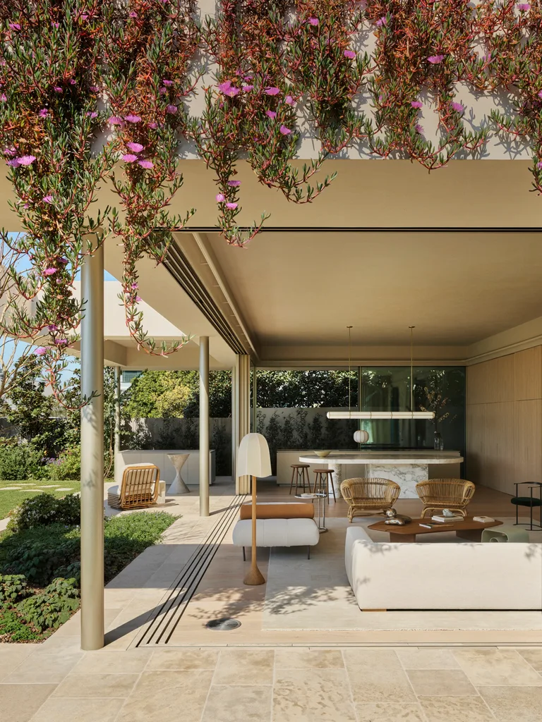 Open-plan living space. The large windows slide open to entirely open up the interior and exterior zones. Inside is an open-plan living and kitchen and on the facade of the building plants hang from the second storey down.