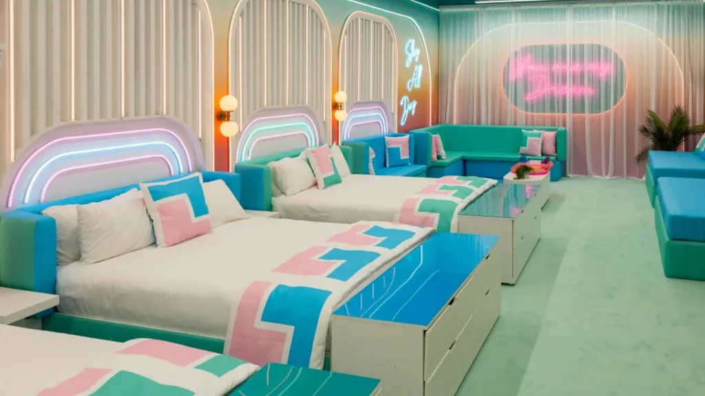 Colorful Love Island USA bedroom with pastel bedding, neon lights, and modern decor, evoking a playful and dreamy atmosphere. There are multiple beds in the space, positioned side by side.
