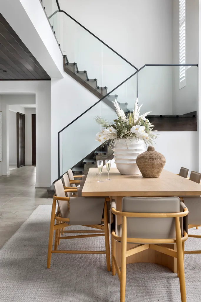 contemporary two storey home with dining room and glass balustrading on staircase