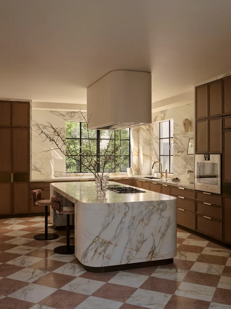 Sleek kitchen with marble island, wooden cabinets, large windows, and checkered floor.