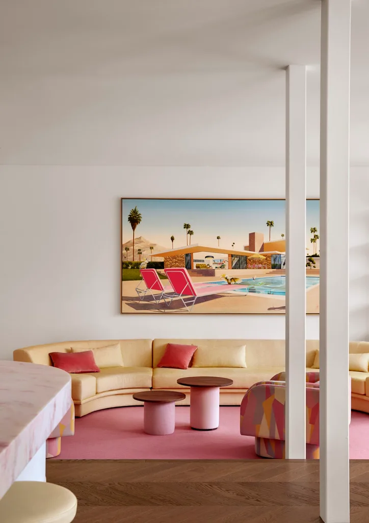 Stylish living room with a beige sectional sofa, colorful pillows, and a large wall art of a poolside scene.