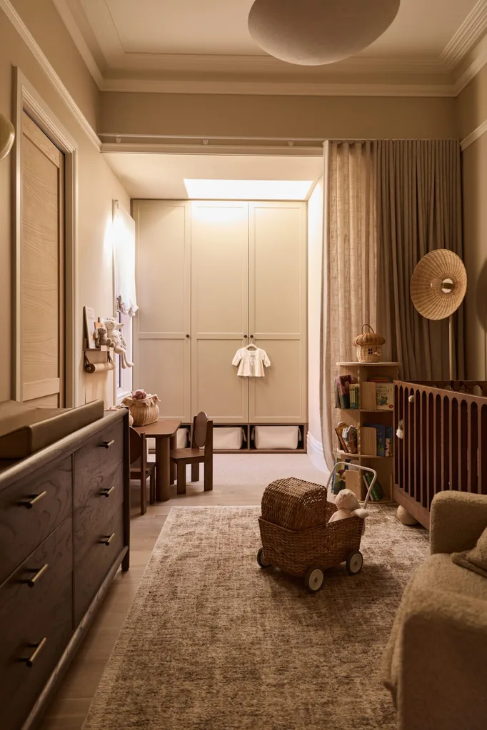 Cozy nursery with wooden furniture, crib, toy cart, and wardrobe. Neutral tones and soft lighting create a warm atmosphere.
