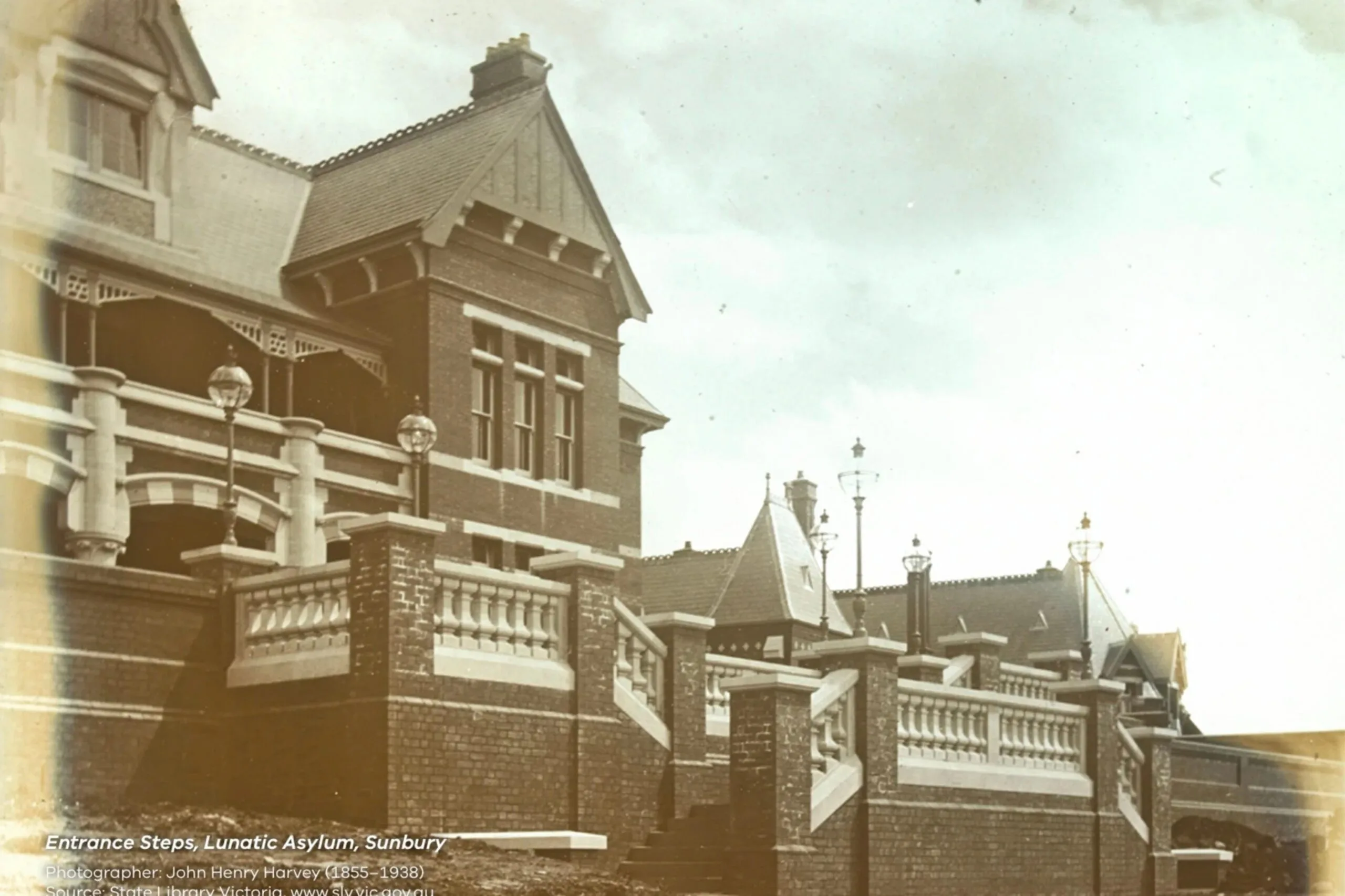 Historic image of entrance steps at Sunbury Lunatic Asylum, featuring ornate architecture and old-style lamps. The Block 2027 location.