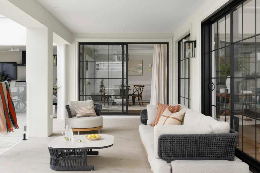 Outdoor lounge with modern furniture, glass doors leading to the dining room; a serene and stylish space for relaxation.