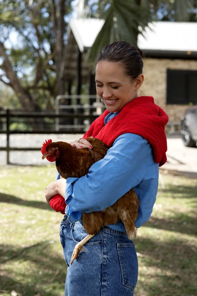 Jesinta Franklin holding a chicken on her property
