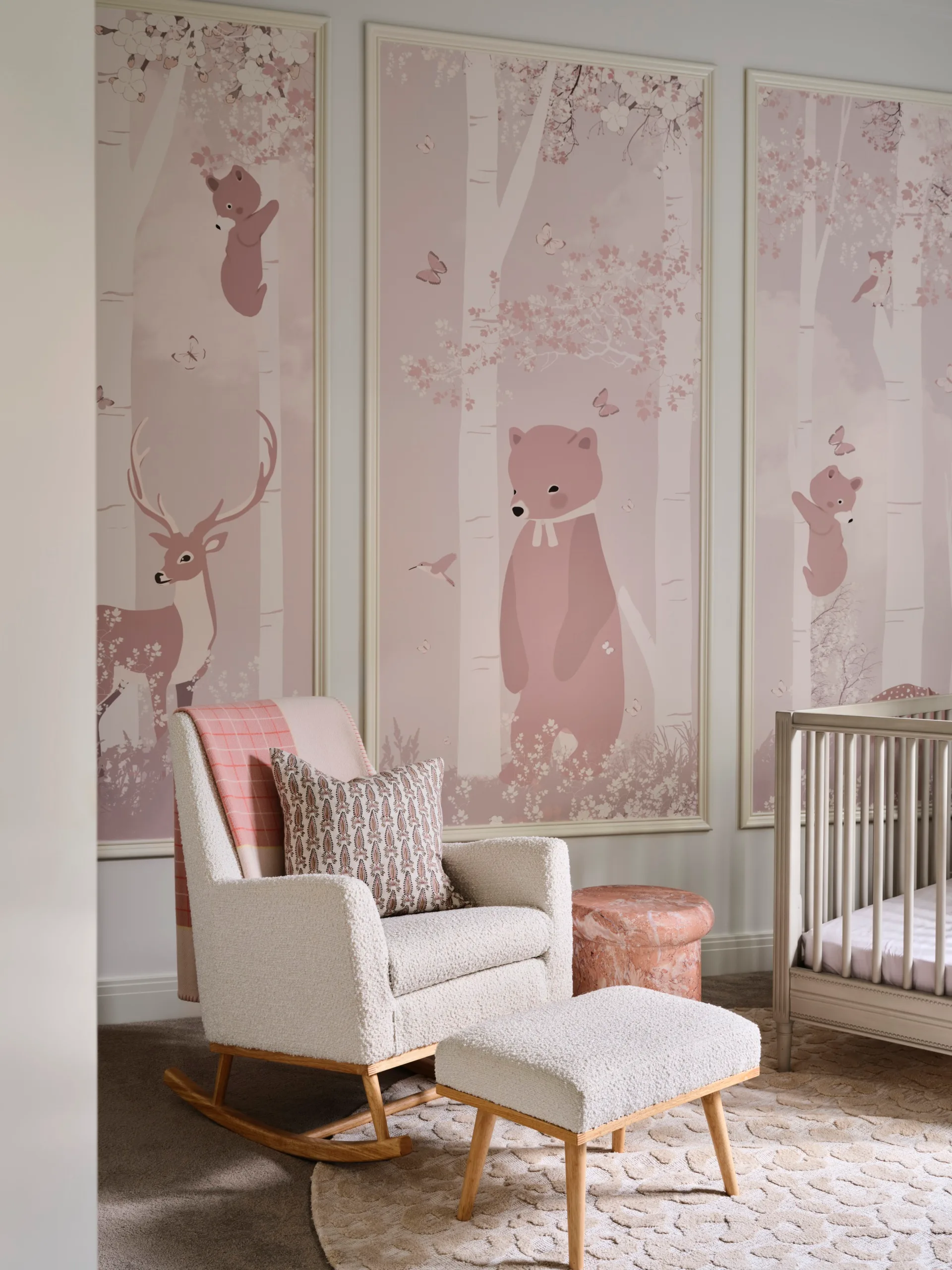 Nursery with pastel animal mural, rocking chair, ottoman, crib, and textured rug.