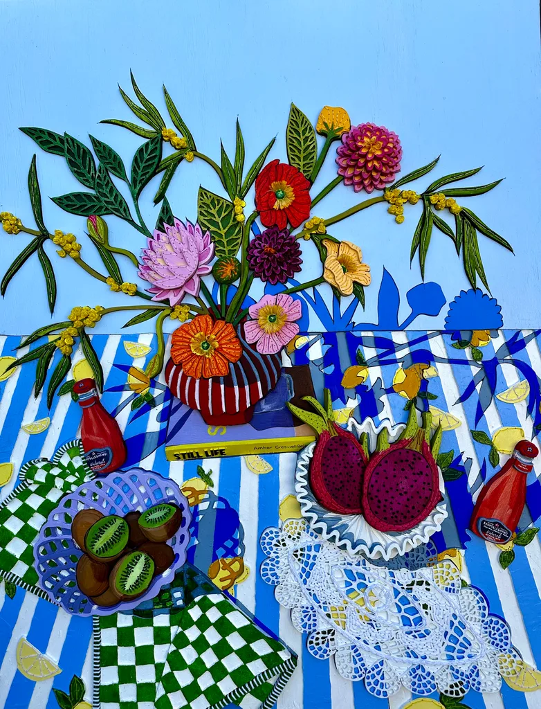 A colourful acrylic painting of a still life scene, featuring bright blue background, blue and white striped tablecloth with flowers on top, a bowl of kiwi fruit and a book.