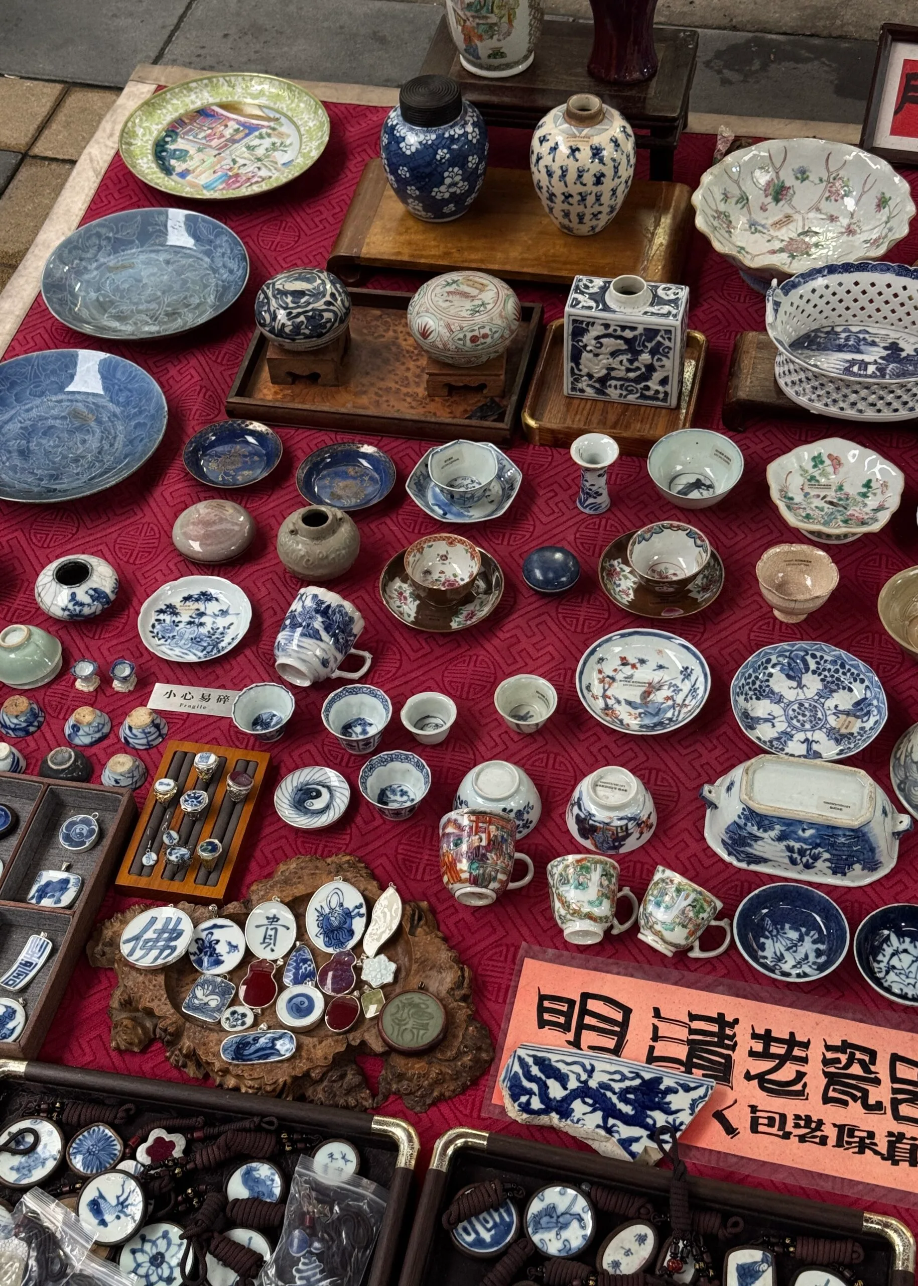 a series of small antique bowls and china laid on a red rug