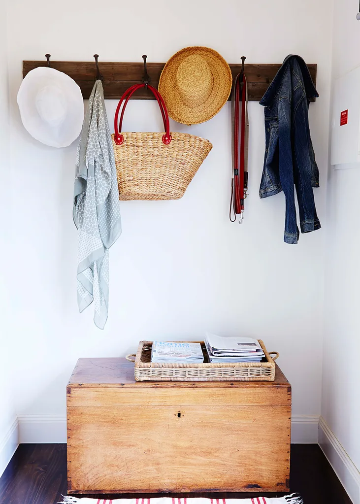 A row of baskets and hats hang from hooks