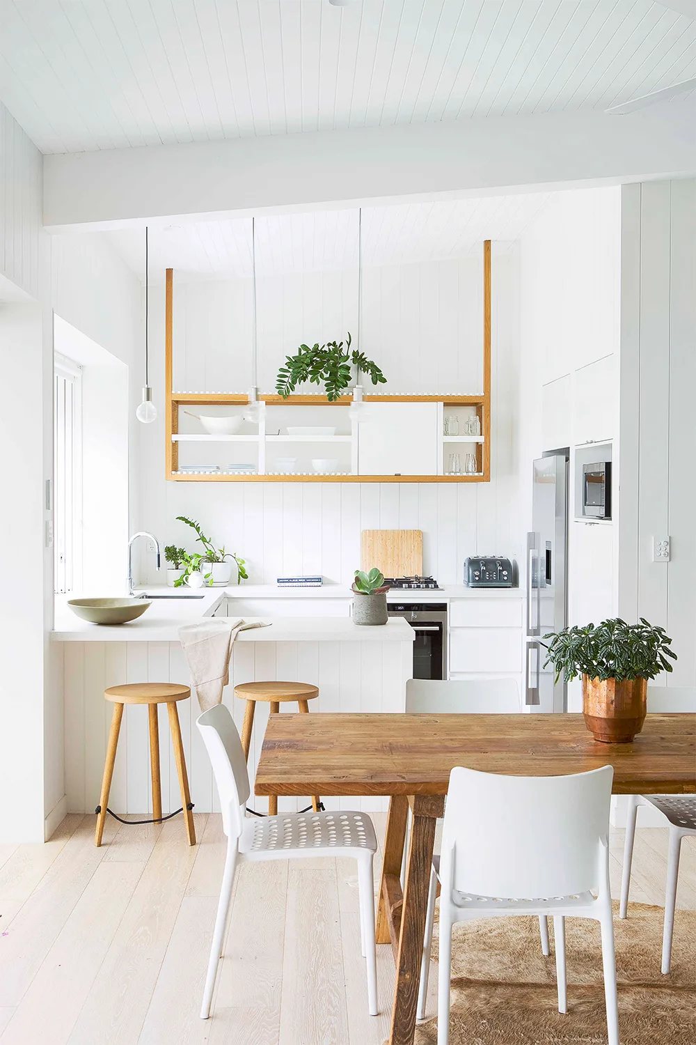 Guest house accommodation with a small white kitchen and light timber accent furniture
