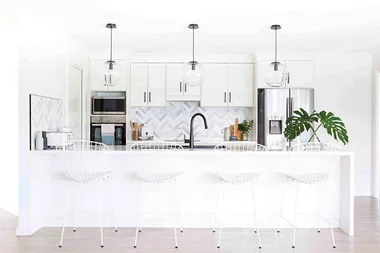 Classic take on a white kitchen - herringbone tiles a winner