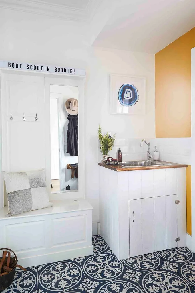 Mudroom with laundry sink and patterned floor tiles