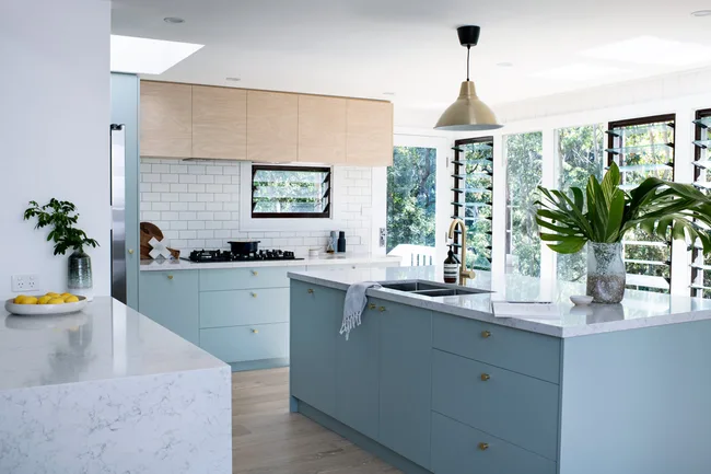 white subway tiled splashback with light blue cabinetry