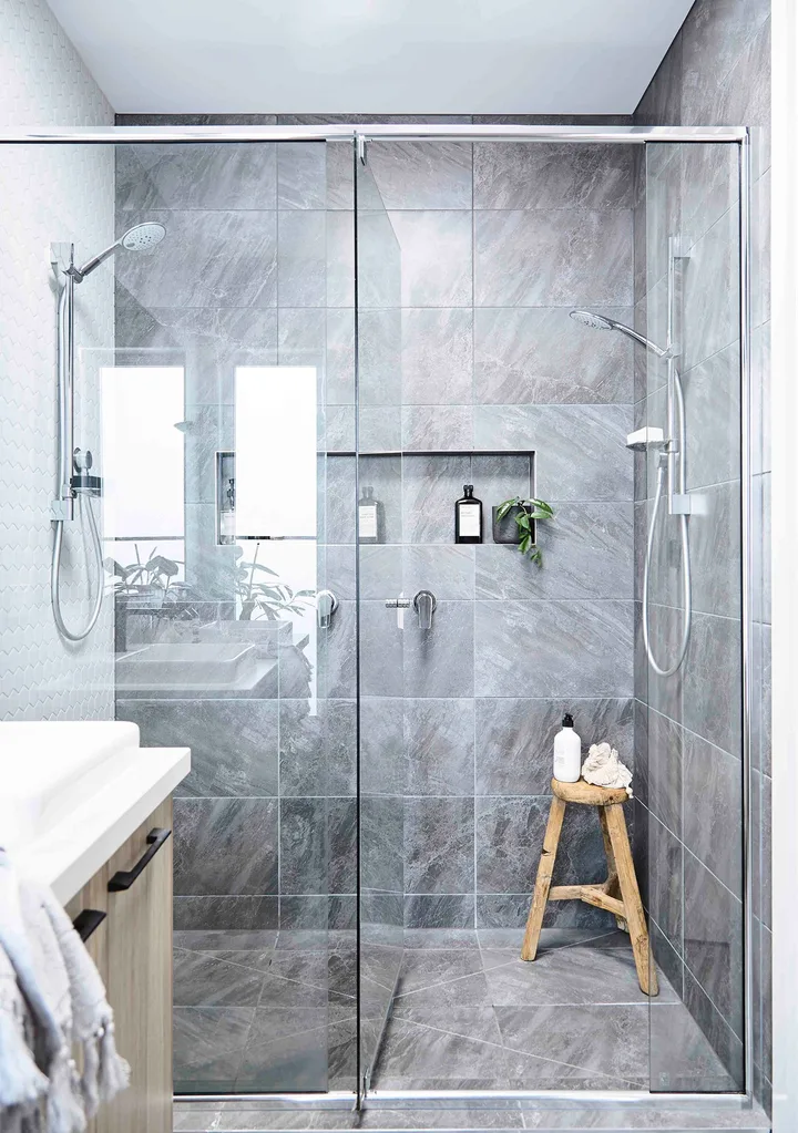 Az and Jamie splashed out on large floor-to- ceiling tiles and a hexagonal tile feature wall in their double shower. Tiles from Surfaces by Hynes, all tapware by Caroma.