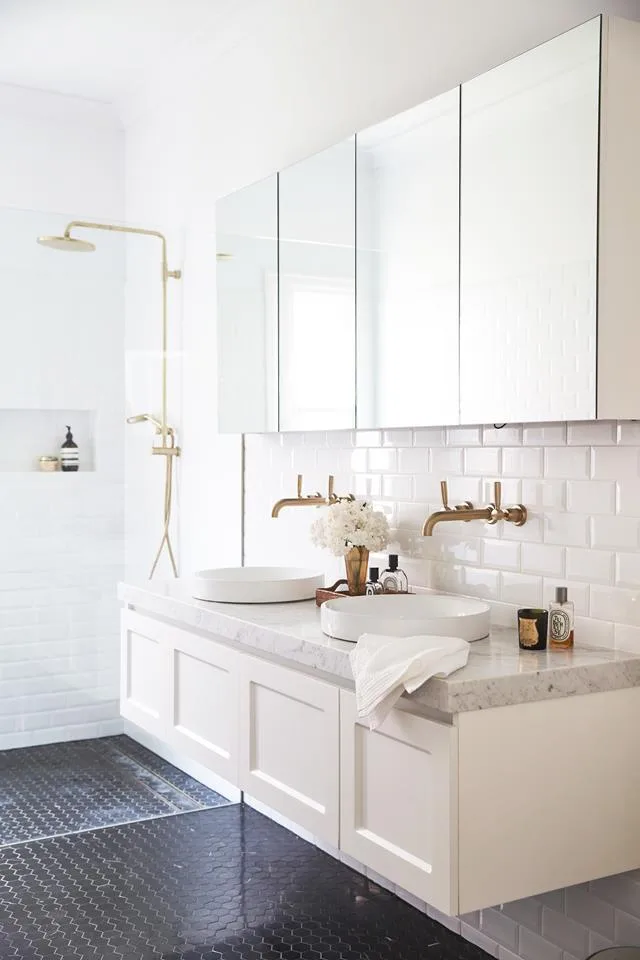 white bathroom with marble vanity top and black hex mosaic floor