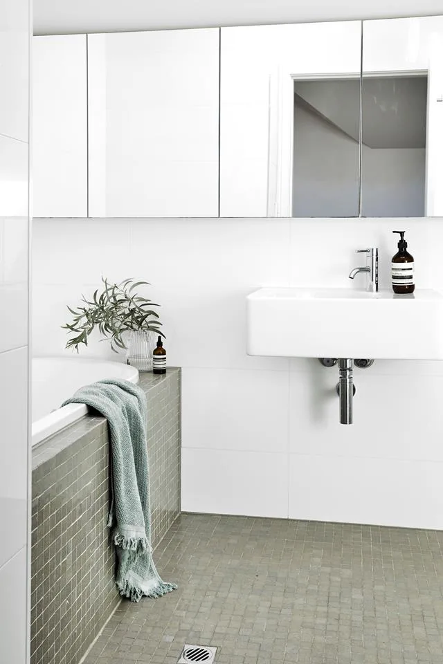 White bathroom with built-in bathtub and sage green mosiac tiles