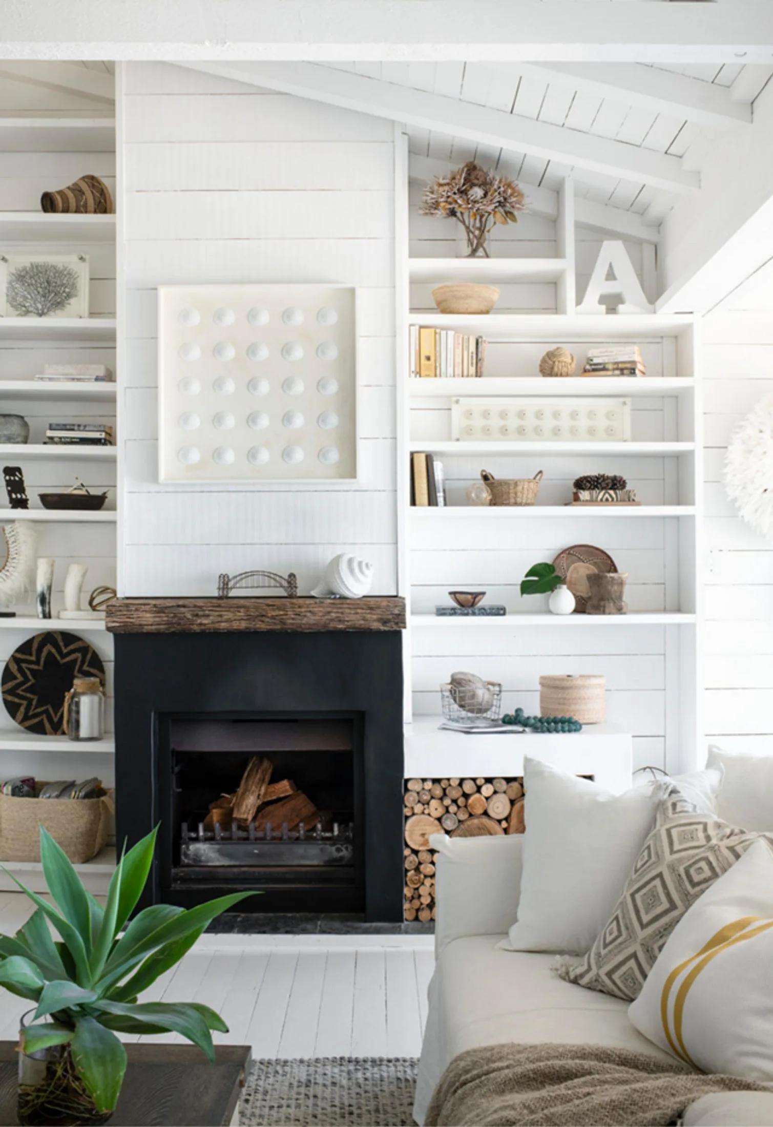 coastal living room with black fireplace and white bookshelves