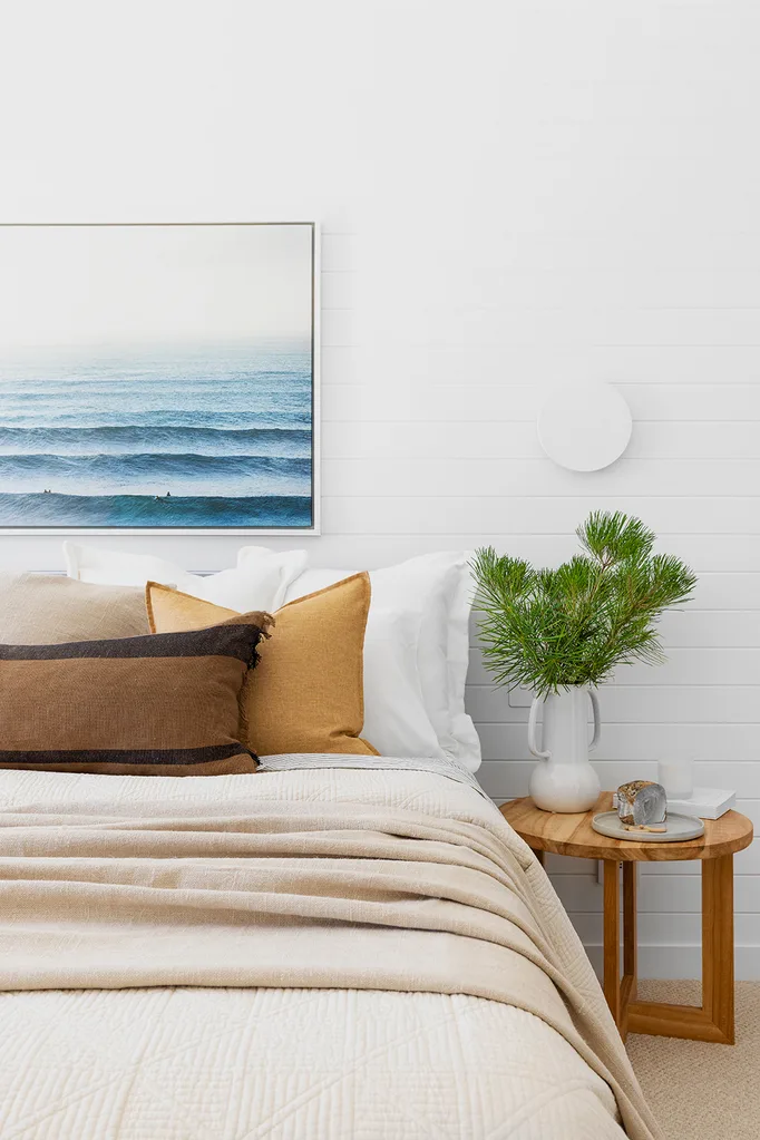 Coastal bedroom with natural bedlinen and ocean print artwork