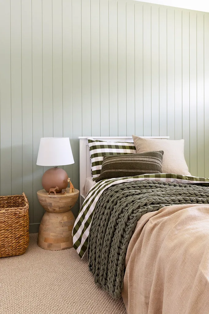 Coastal bush bedroom with eucalyptus green VJ panelled walls and checked bedlinen