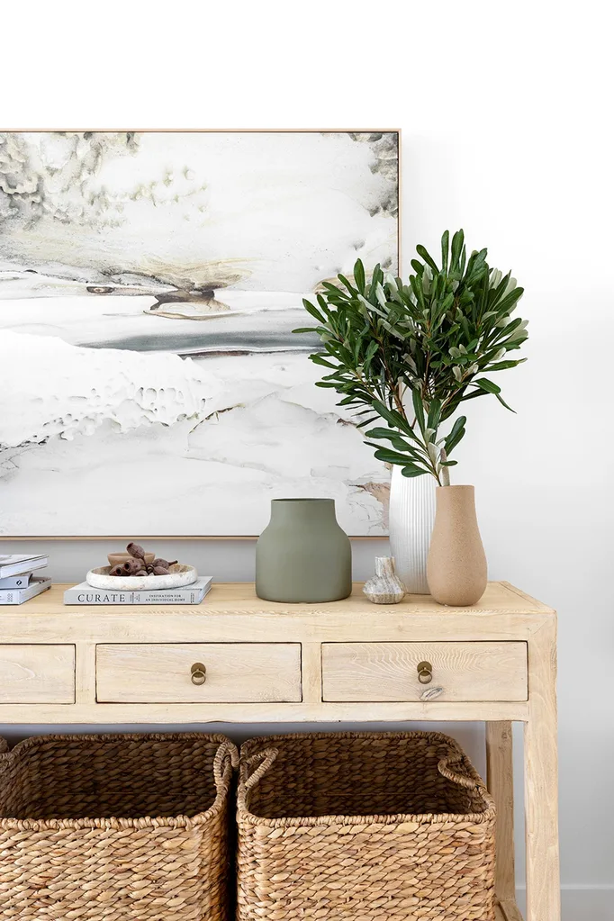 coastal style home entrance with timber console, storage baskets and neutral artwork
