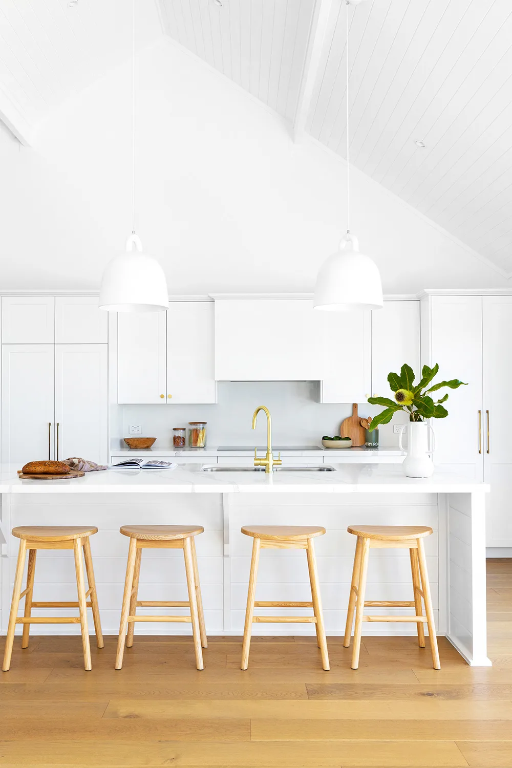 white coastal style kitchen with pendant lighting