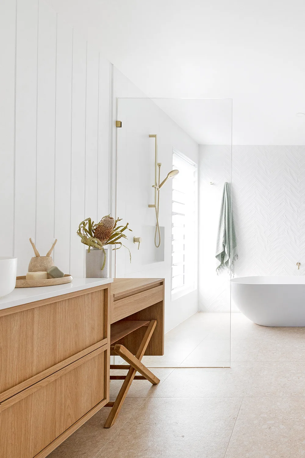 Coastal bathroom with timber vanity brass fittings and freestanding bathtub
