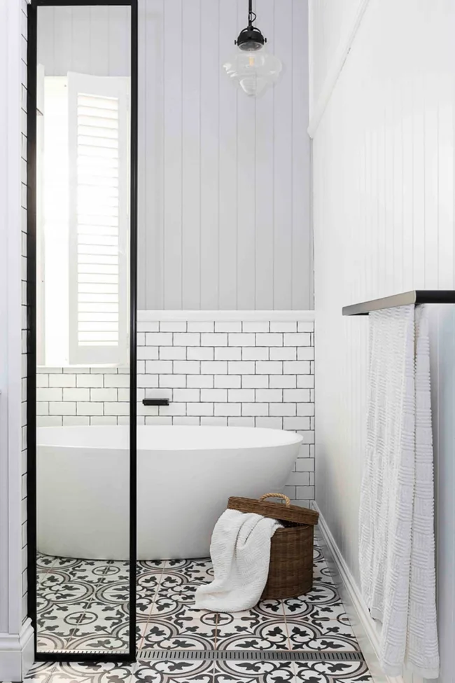 Black and white bathroom with patterned tile floor VJ panelled walls and black grouted subway tiles