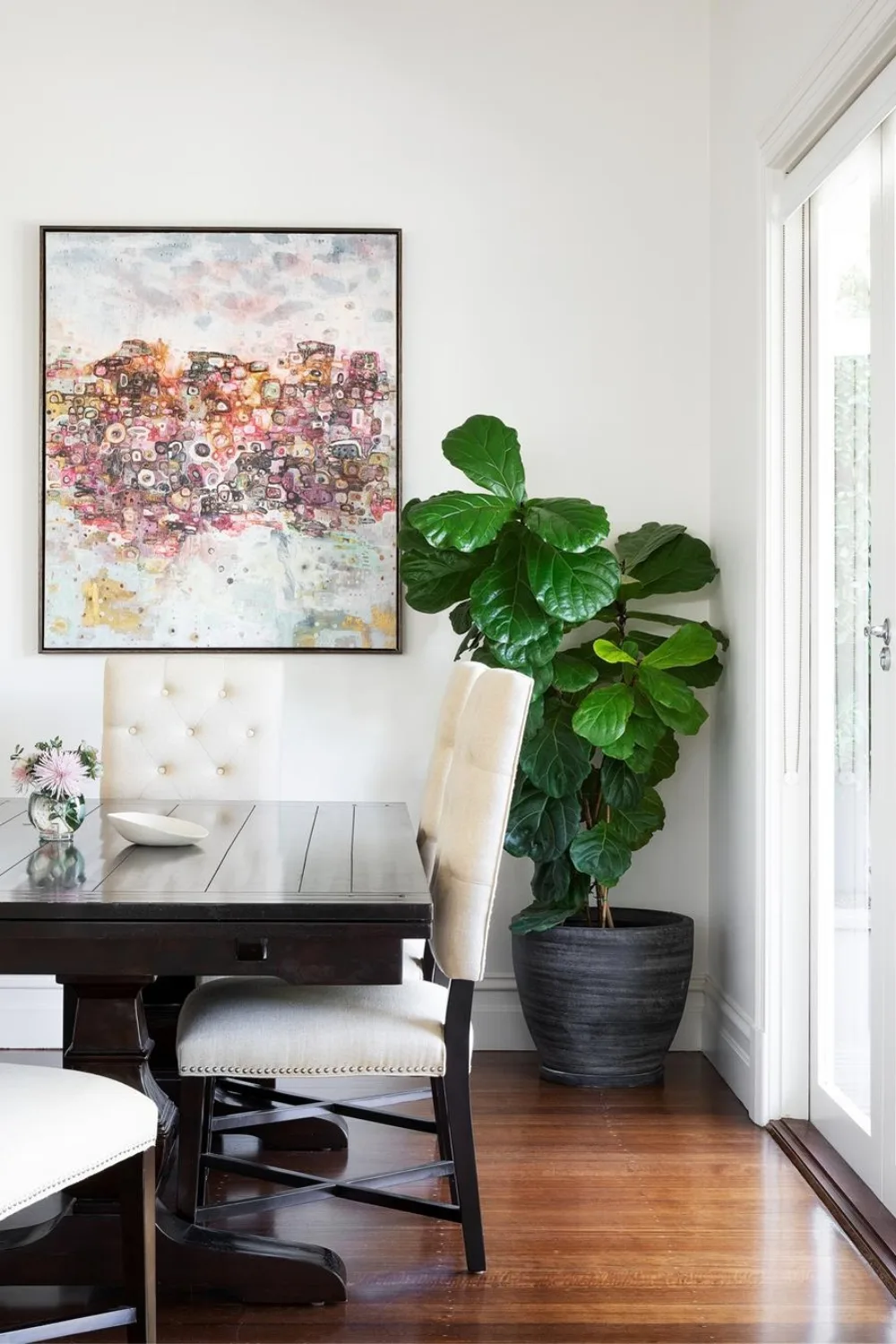 Dining table with artwork and fiddle leaf fig