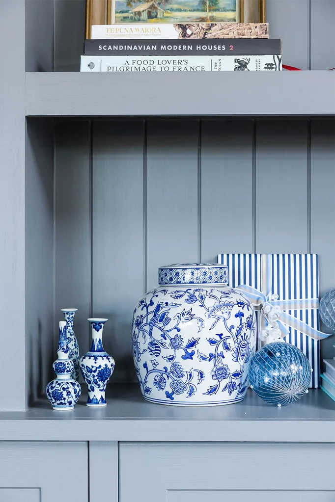 Bookshelf detail with blue and white ginger jar and Christmas decoration