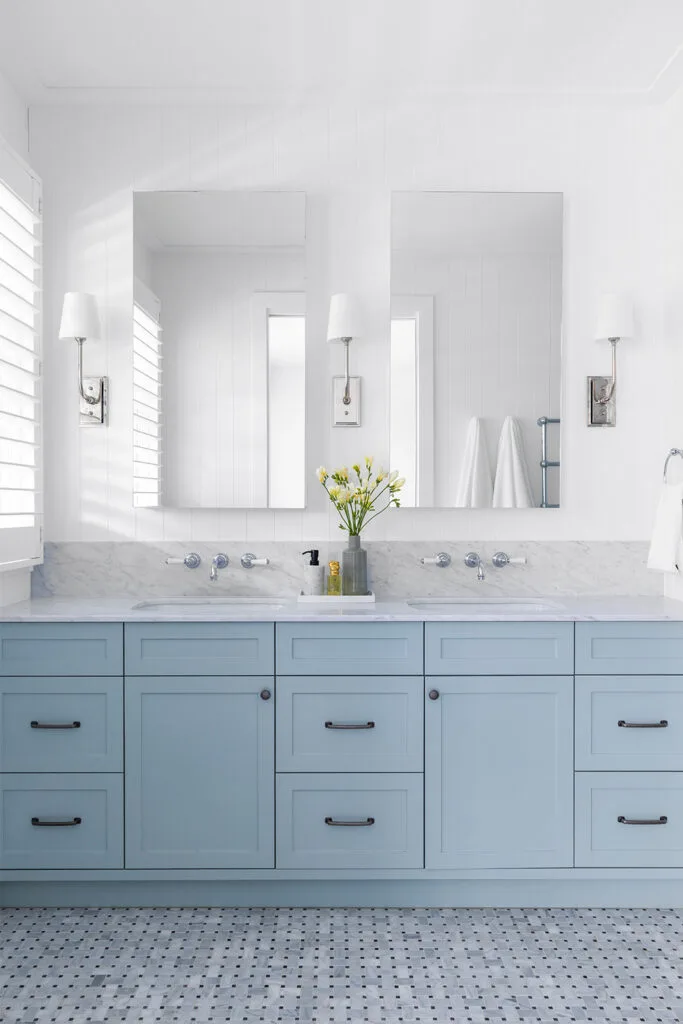 Pale blue bathroom cabinets with hexagonal marble mosaic floor tiles