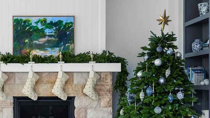 Coastal Christmas living room with blue and silver Christmas tree and sandstone fireplace