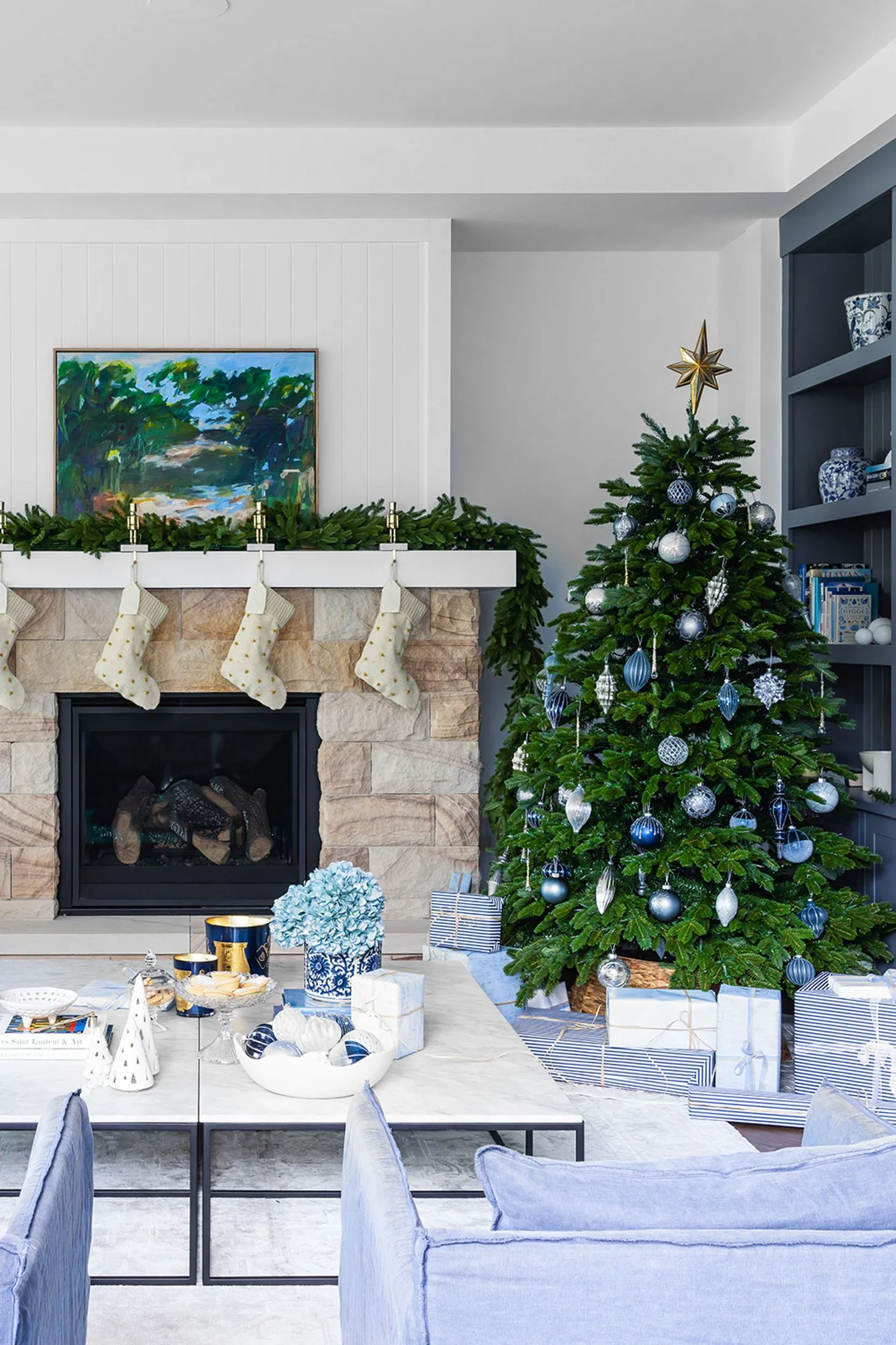 Coastal Christmas living room with blue and silver Christmas tree and sandstone fireplace