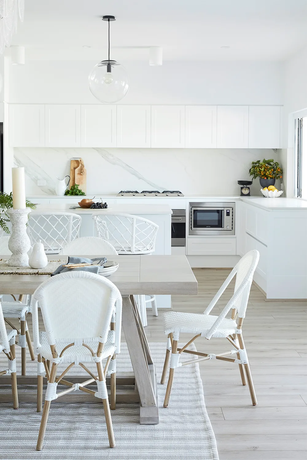 White eat-in kitchen dining room with white wicker chairs