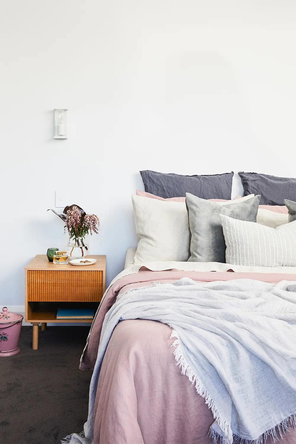 Main bedroom with pink bedlinen and timber bedside table