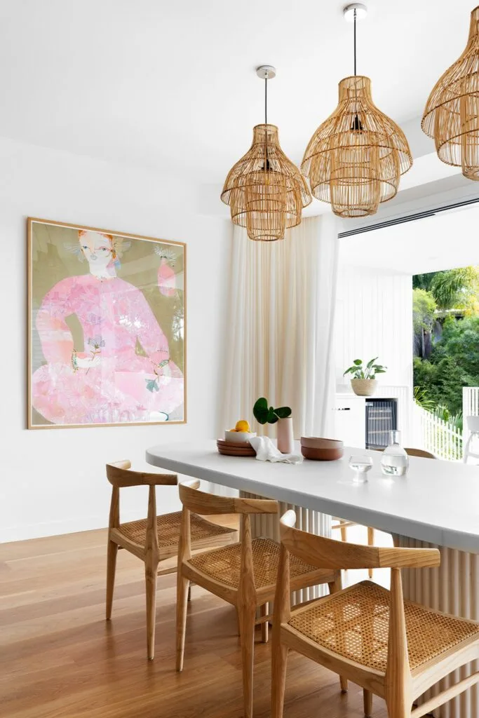 Contemporary dining room with a trio of rattan pendant lights and timber and rattan dining chairs