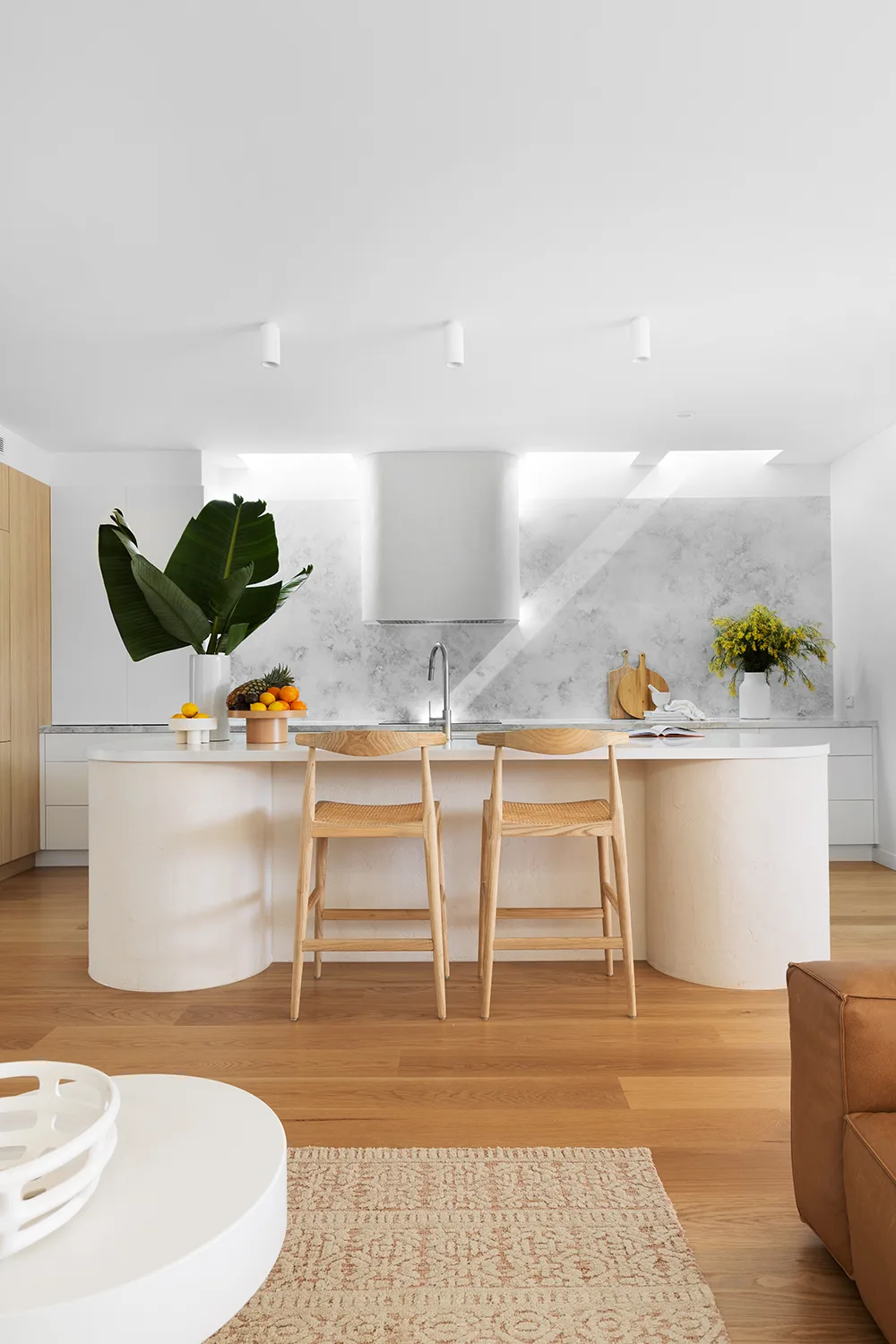 Contemporary minimalist kitchen with oak cabinetry and gray quartz splashback