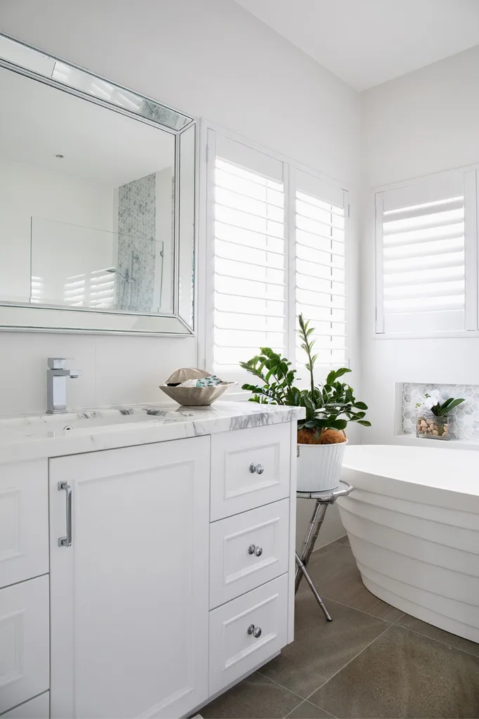 White and marble bathroom with zanzibar gem on plant stand