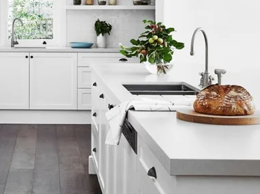 All white galley kitchen with dark timber flooring and concrete benchtops