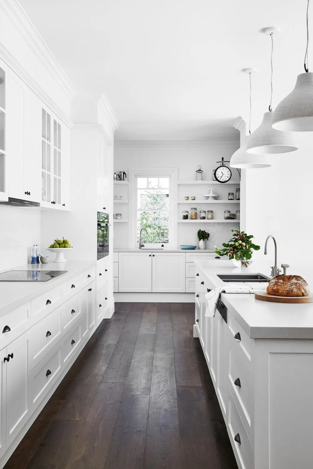 All white galley kitchen with dark timber flooring and concrete benchtops