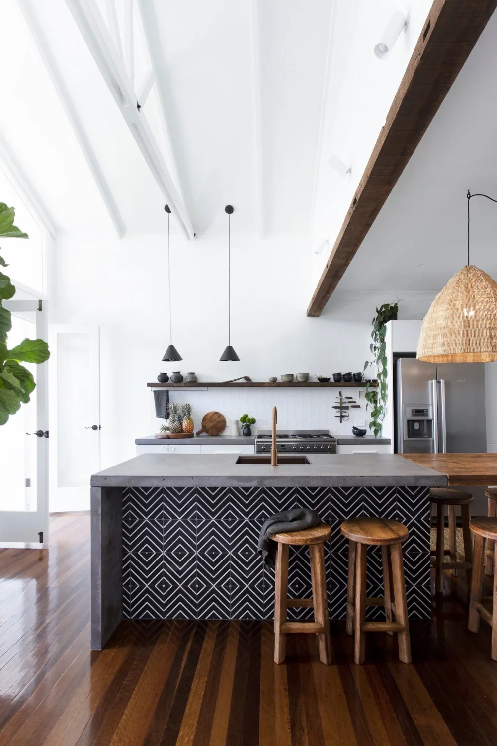 Modern farmhouse kitchen with concrete island bench clad in feature geometric tiles