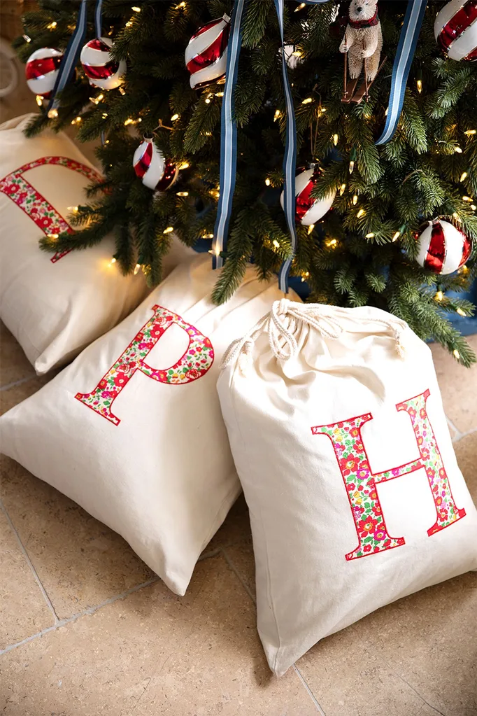 Monogrammed Santa sacks under a blue and silver Christmas tree