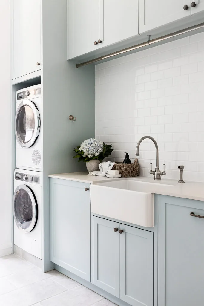 Pale blue laundry hanging rail stacked washer dryer